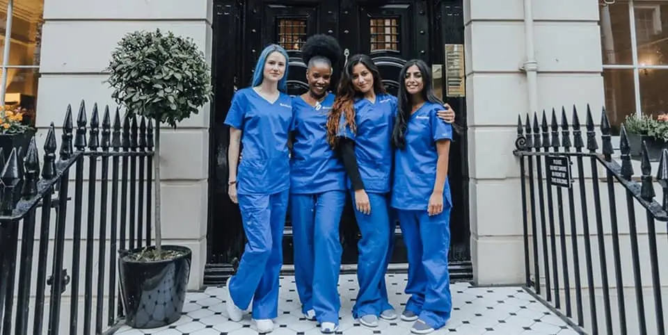 Four nurses in blue scrubs outside a Georgian clinic entrance for Ultherapy skin lifting in Dublin